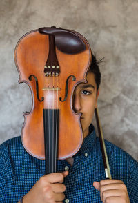 Boy posing with violin in house