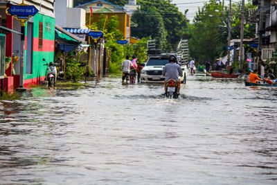 People on wet street in city