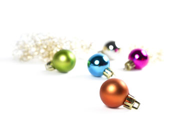 Close-up of multi colored balls on table against white background