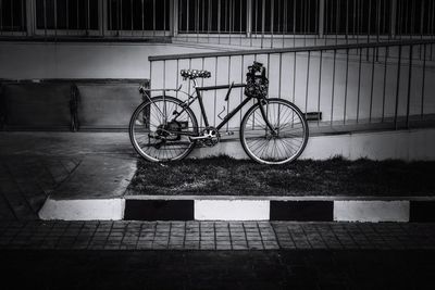 Bicycle parked on footpath against wall