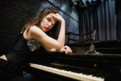 Full length of a young woman playing piano