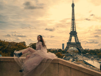 Woman tower against cloudy sky