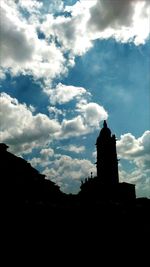 Silhouette built structure against cloudy sky