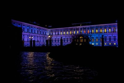 Illuminated building in water at night