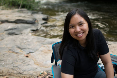 Portrait of smiling young woman on rock