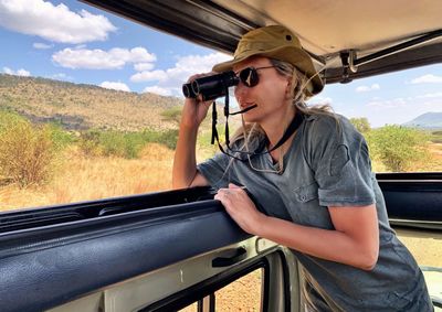 Woman standing in car during safari