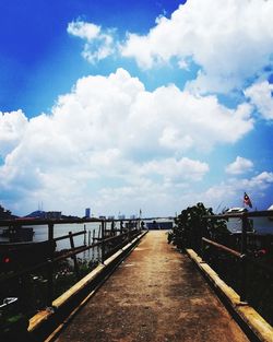 Footpath amidst buildings against sky
