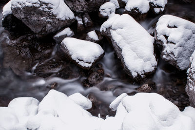 High angle view of snow on rocks in sea