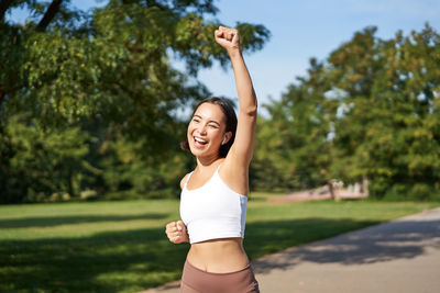 Full length of young woman exercising at park