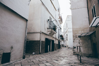 Footpath amidst buildings in city