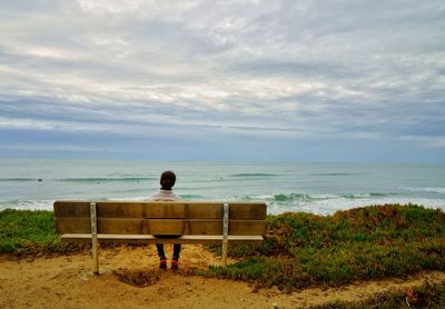 Rear view of girl looking at sea against sky