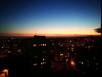 High angle view of illuminated buildings against sky at night