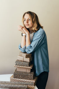 Portrait of smiling woman standing against wall