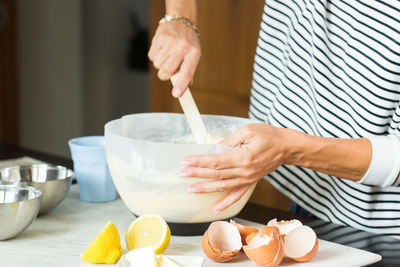 Woman kneading the dough while cooking apple pie in the modern kitchen