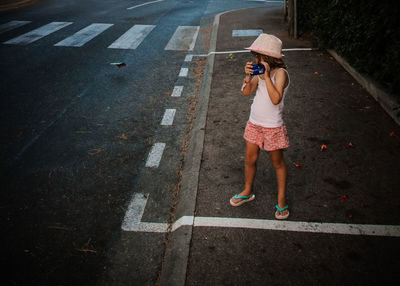 High angle view of boy photographing on road