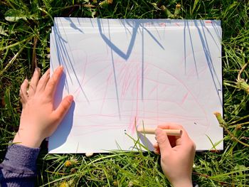 Low section of woman holding hands on field