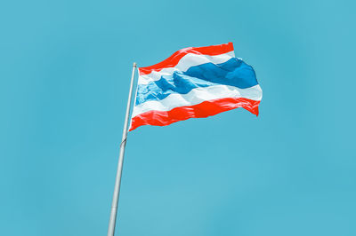 Low angle view of flag against blue sky