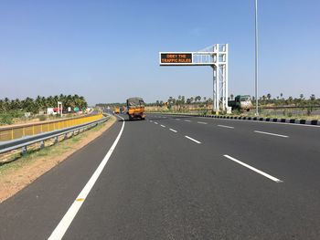 Road sign against clear blue sky