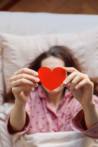 Midsection of woman holding heart shape