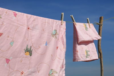 Close-up of clothespins holding laundry on clothesline during sunny day