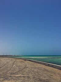 Scenic view of beach against clear blue sky