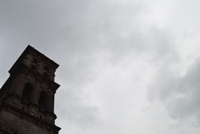 Low angle view of tower against cloudy sky