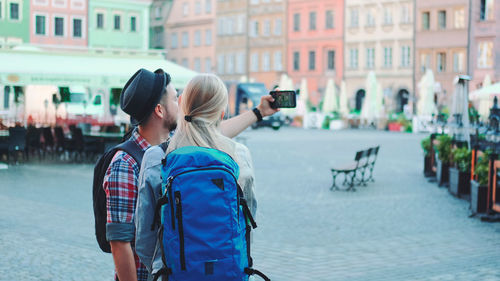 Rear view of people walking on street in city