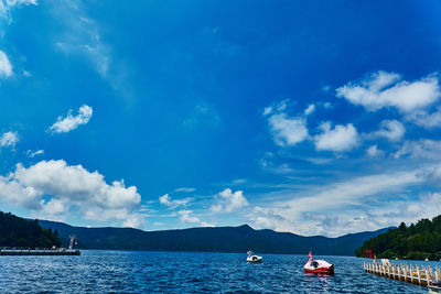 Boats in lake against blue sky
