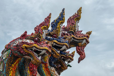 Low angle view of dragon statues against sky