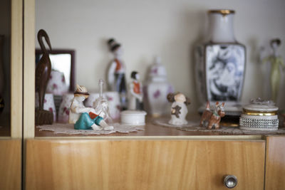 Close-up of figurines on showcase at home