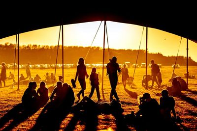 Silhouette people on beach at sunset