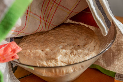 Close-up of hand holding bowl on table