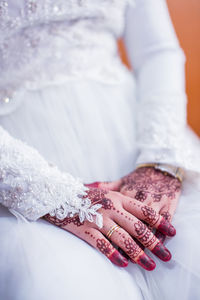 Midsection of bride with henna tattoo