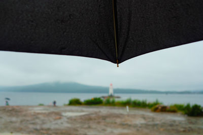 Close-up of water drops on beach against sky