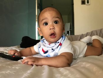 Close-up of baby boy lying on bed at home