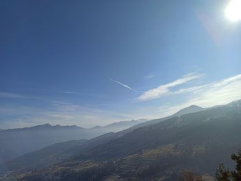 Sunlight streaming on mountain against sky