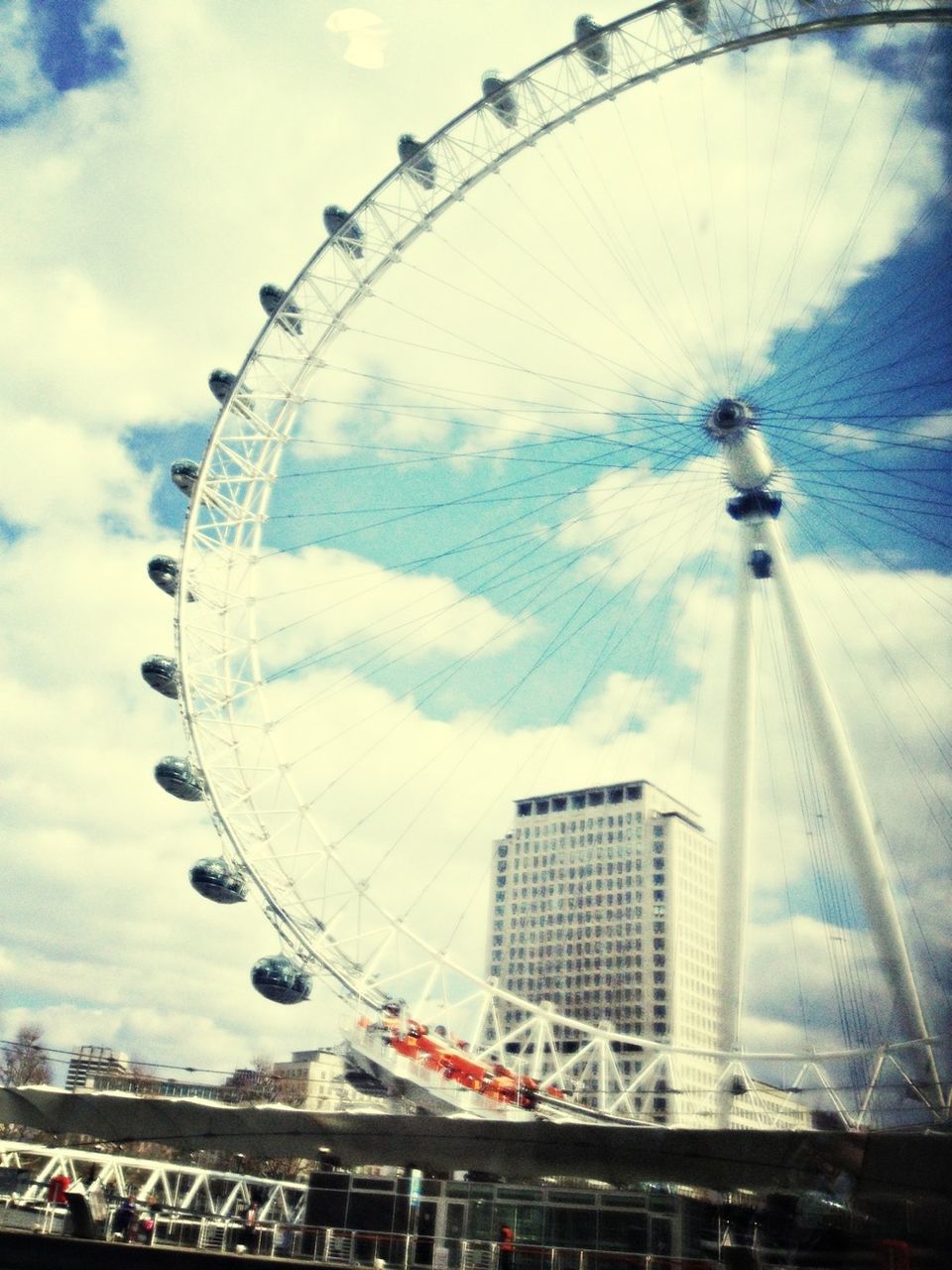 ferris wheel, amusement park ride, amusement park, arts culture and entertainment, sky, low angle view, built structure, fun, architecture, tall - high, cloud - sky, travel destinations, enjoyment, tourism, leisure activity, millennium wheel, day, circle, famous place, city