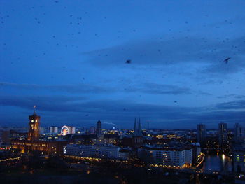 Illuminated buildings in city at dusk