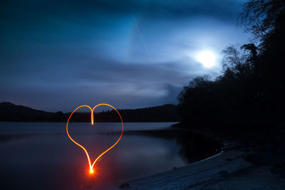 Scenic view of lake against sky at night