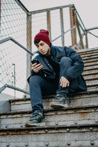 Low angle view of man sitting on staircase