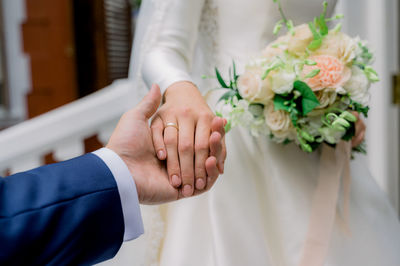 Crop newlyweds holding hands during wedding