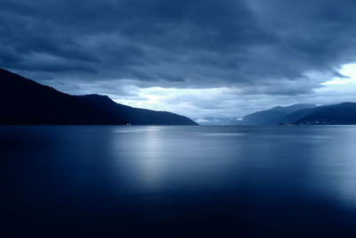 Scenic view of sea and mountains against sky