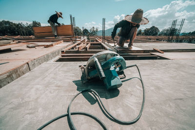 People working at construction site against sky