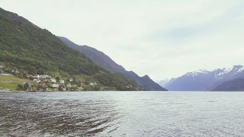 Scenic view of lake by mountains against sky