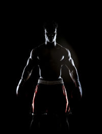 Boxer standing against black background