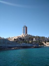 View of sea and buildings against clear sky