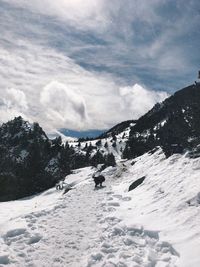 Scenic view of snowcapped landscape against cloudy sky