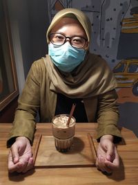 A woman sitting in a coffee shop during the pandemic