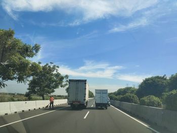 Vehicles on road against sky