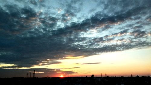 Low angle view of silhouette buildings against dramatic sky